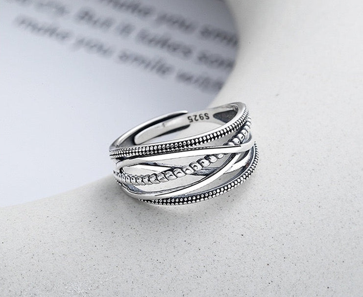Sterling silver minimalist open ring with textured and beaded bands on white background