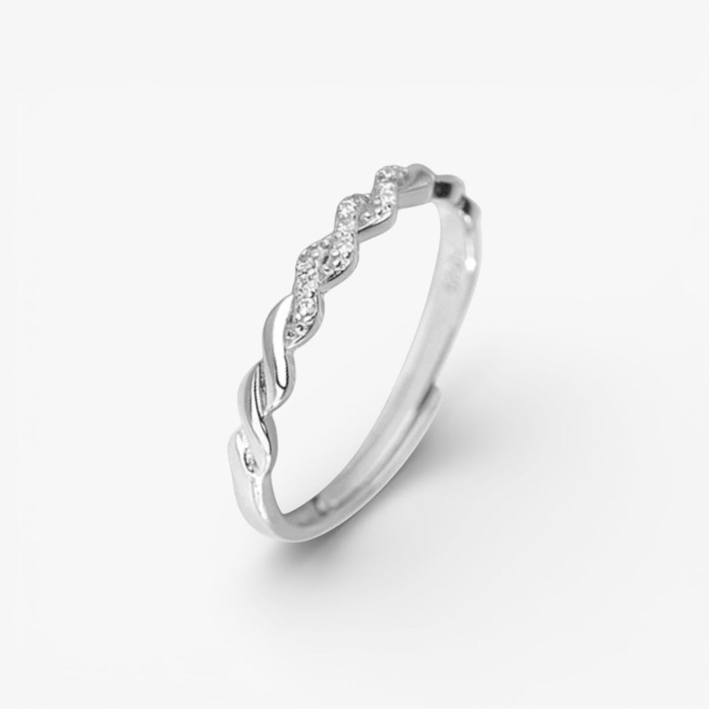 silver twisted band ring with minimalist design and pavé stones on white background