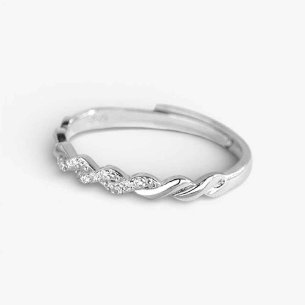 Minimalist silver twisted ring with subtle pavé stones on white background