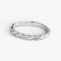 Minimalist silver twisted ring with subtle pavé stones on white background