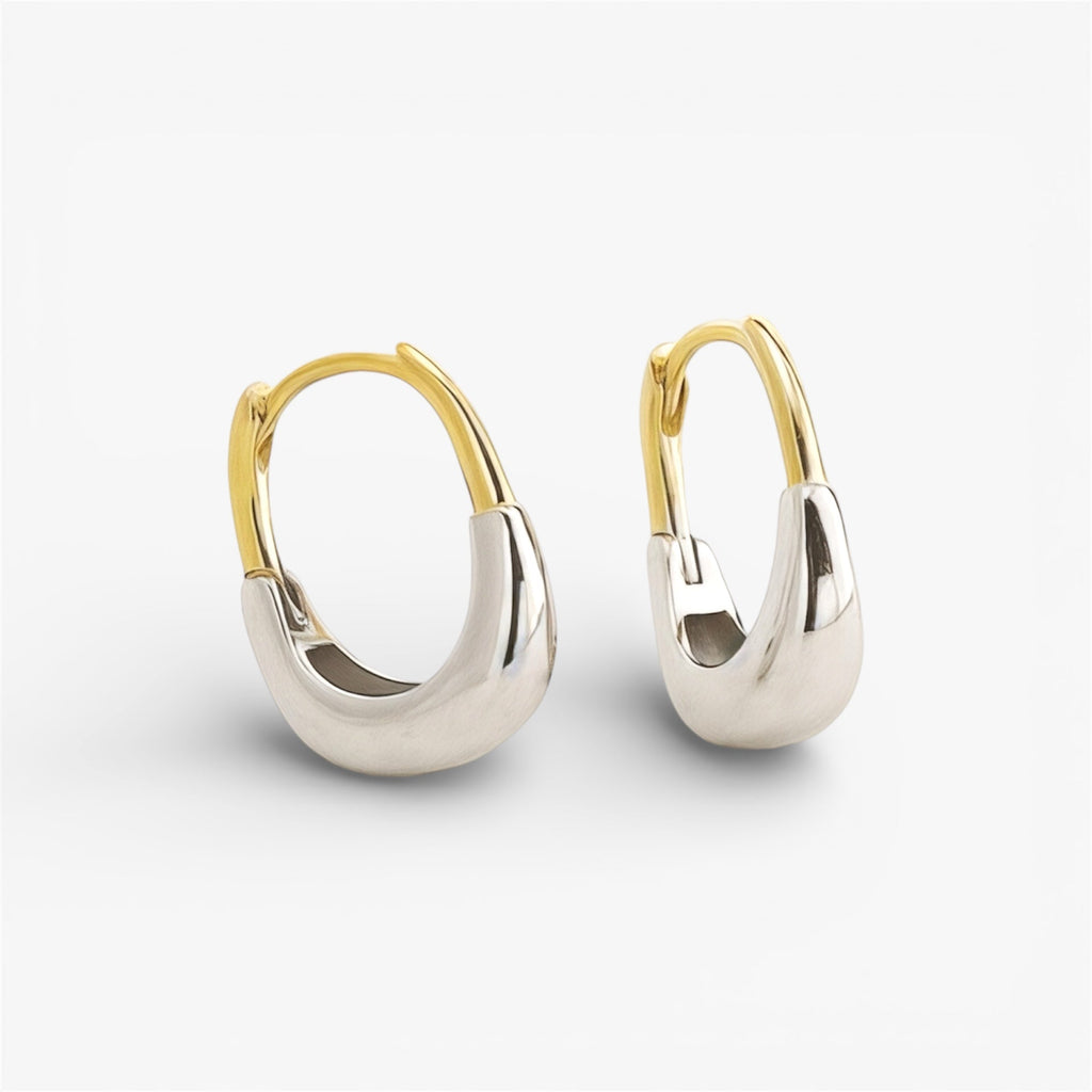 Minimalist gold and silver chunky hoop earrings on white background, modern jewelry
