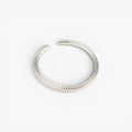 Textured minimalist silver open ring on white background, modern jewelry design