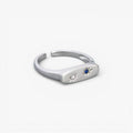 Minimalist silver open ring with star-set clear and blue gemstones on white background