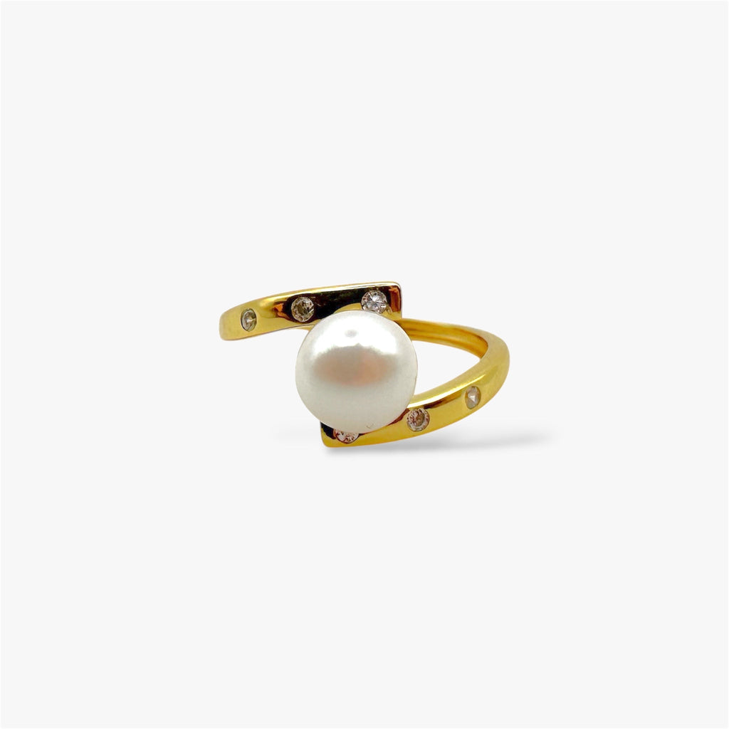 Gold wrap ring with central white pearl and small crystal accents on white background