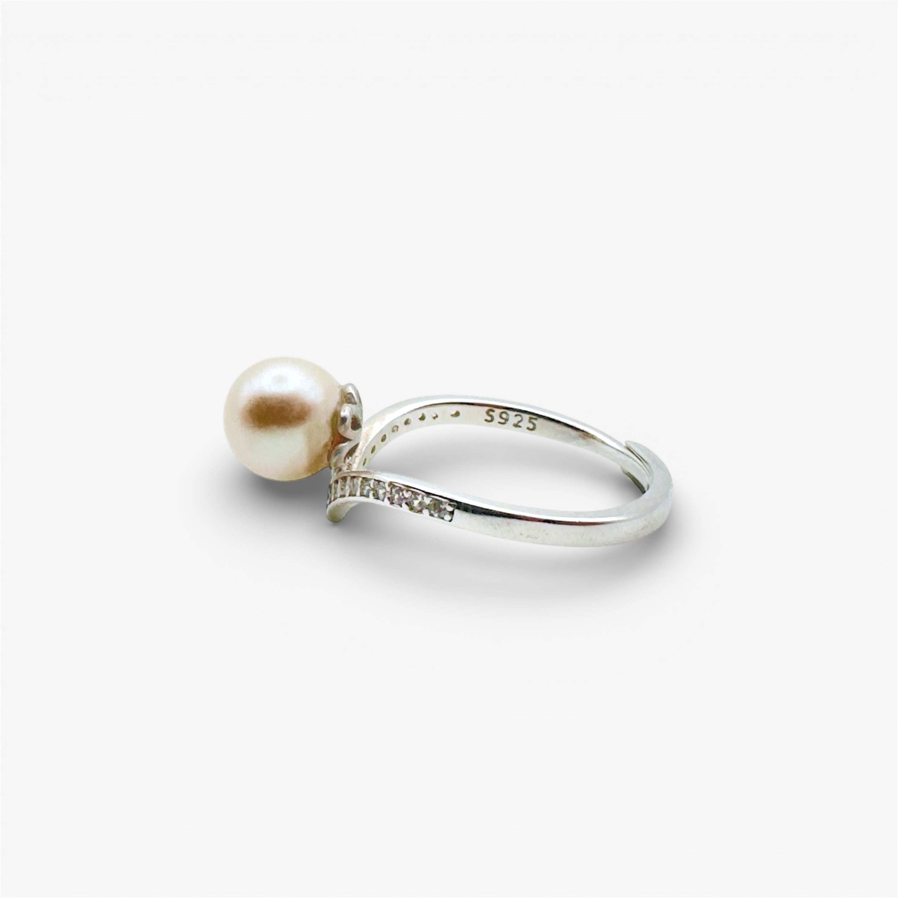 Sterling silver ring with white pearl and small accent stones on a minimalist band