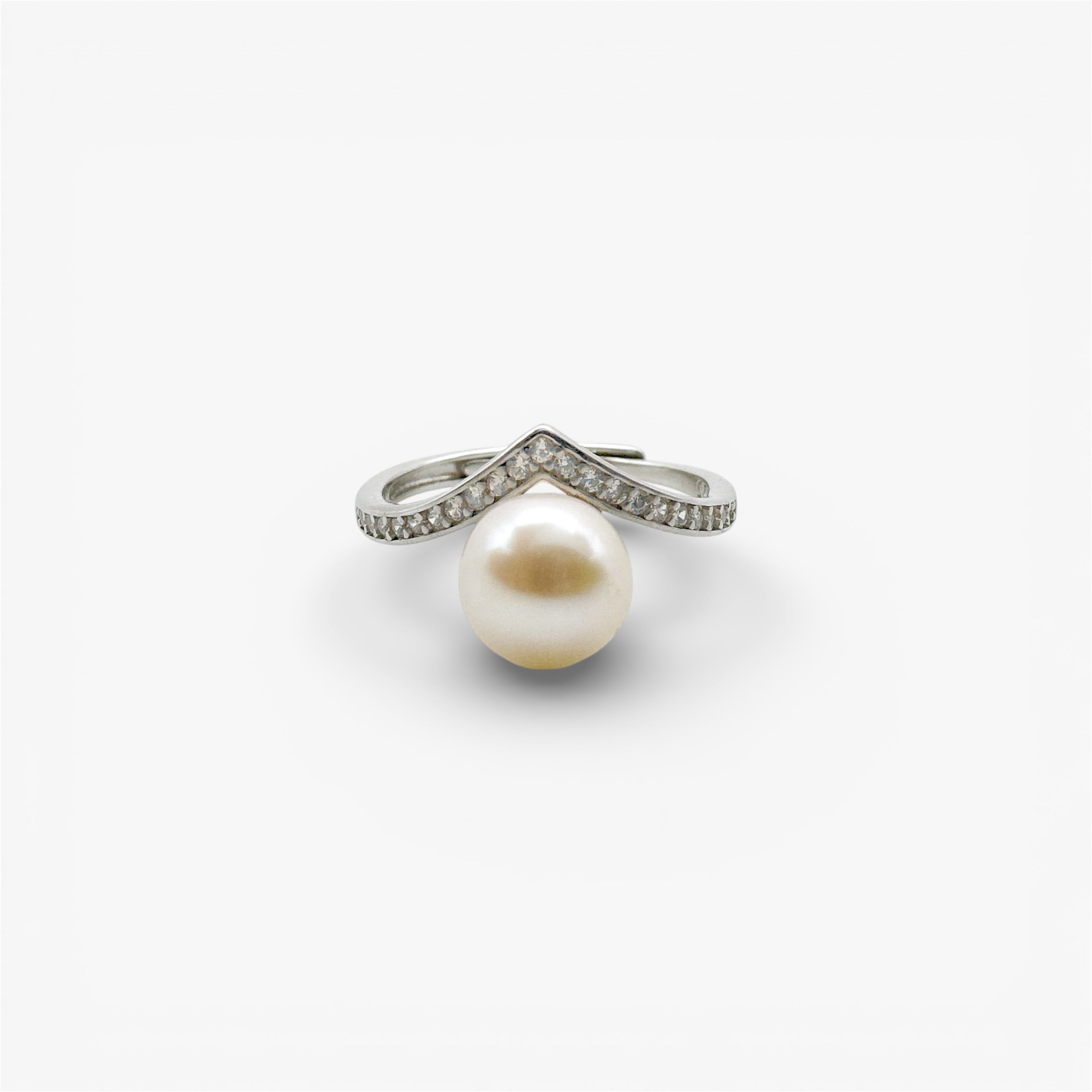 Modern silver ring with large pearl and pavé-set cubic zirconia on white background