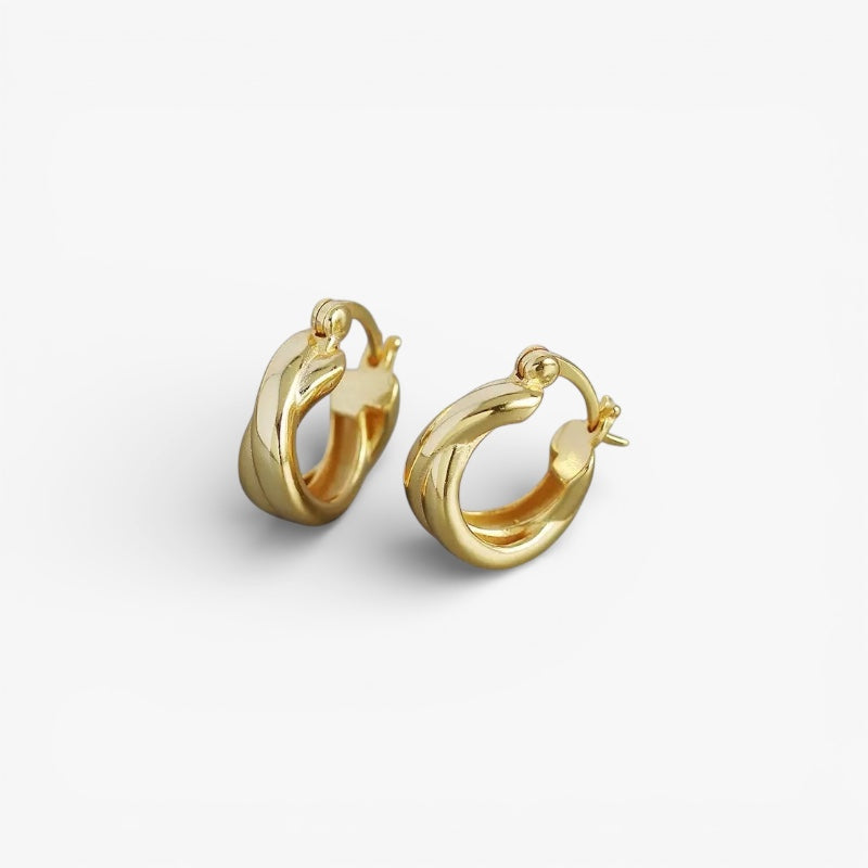 Chunky gold twisted hoop earrings, minimalist modern design on white background