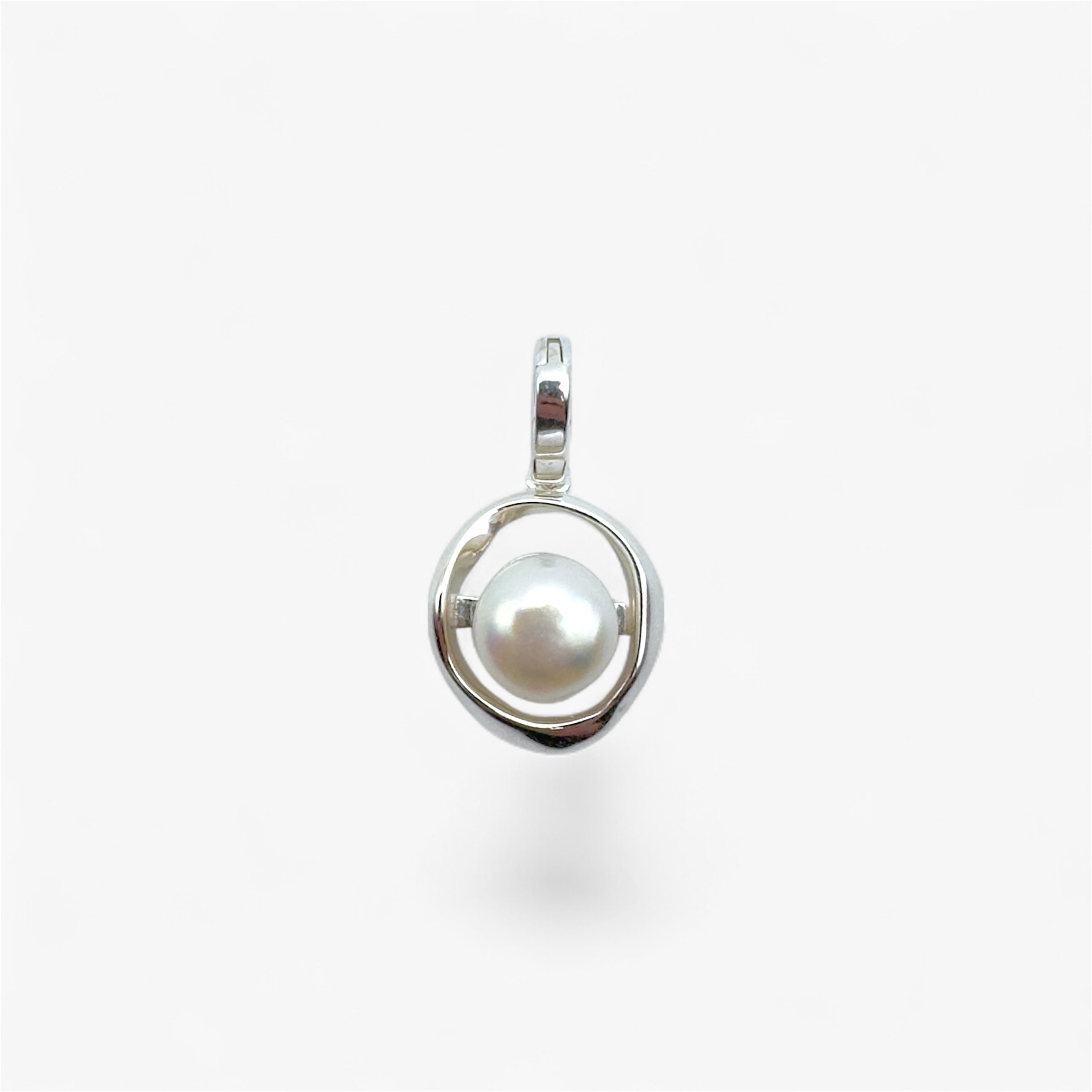 Minimalist silver pendant with round white pearl on white background