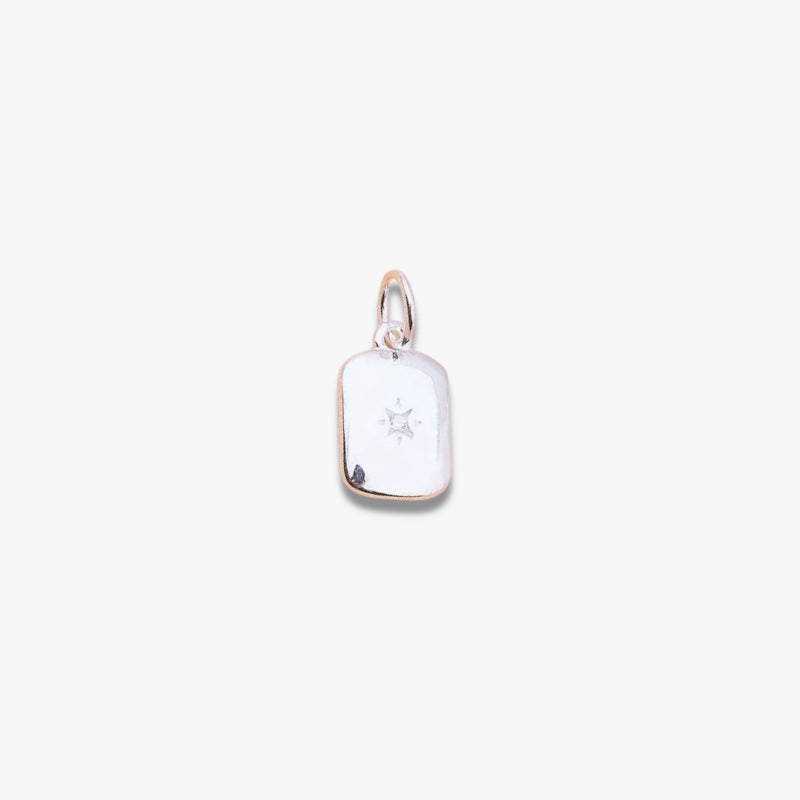 Rectangular silver pendant with a small engraved star, minimalist jewellery on white background
