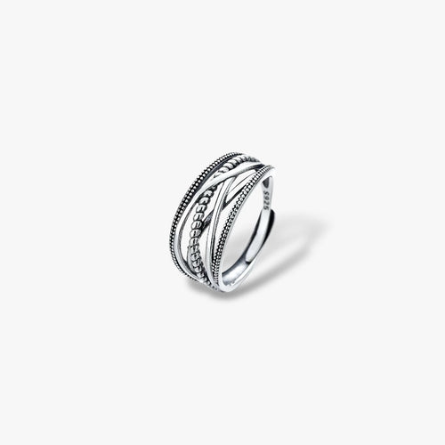 Sterling silver ring with intricate textured bands, minimalist modern jewelry on white background.