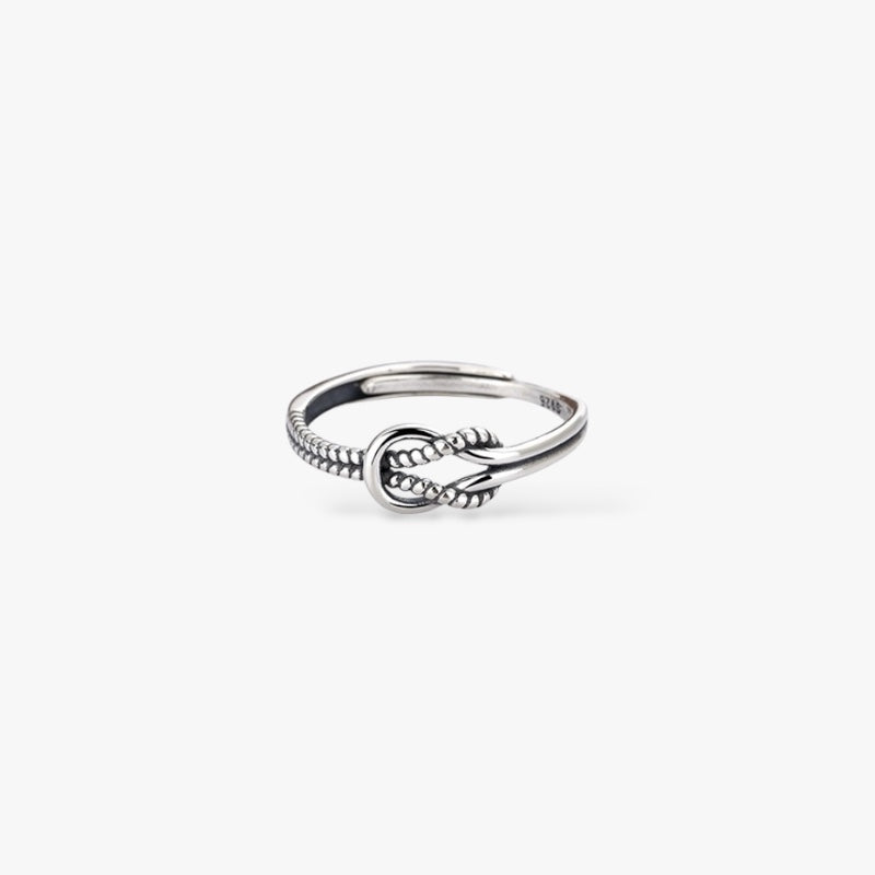 Sterling silver knot ring with beaded detailing, minimalist modern jewelry on white background