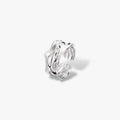 Modern minimalist silver ear cuff with textured, wavy design on white background
