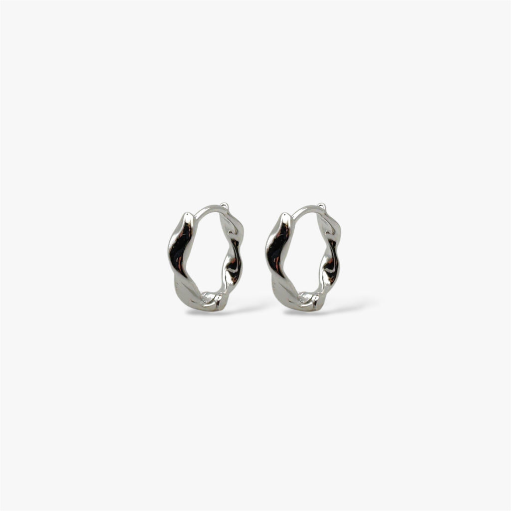 Organically-shaped silver huggie hoop earrings.