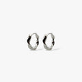 Organically-shaped silver huggie hoop earrings.
