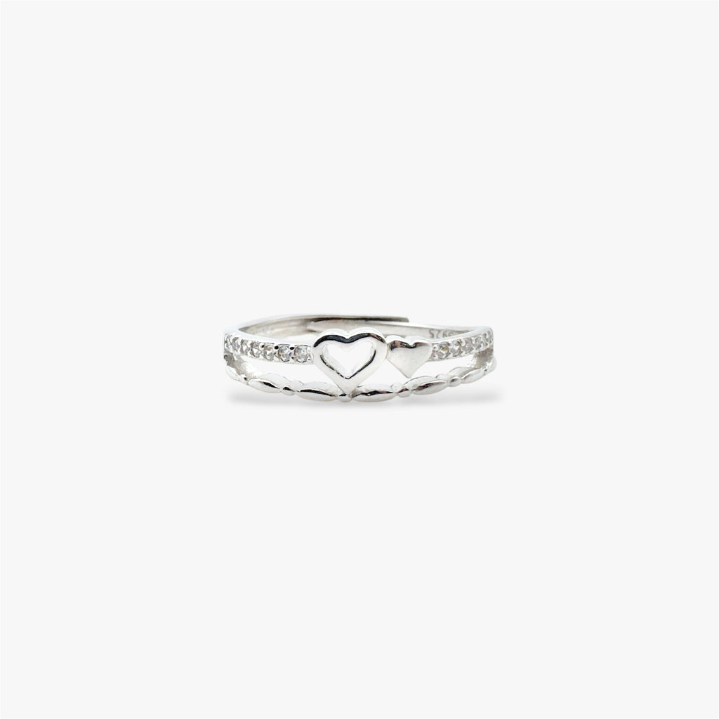 Silver ring with a heart design and crystals.