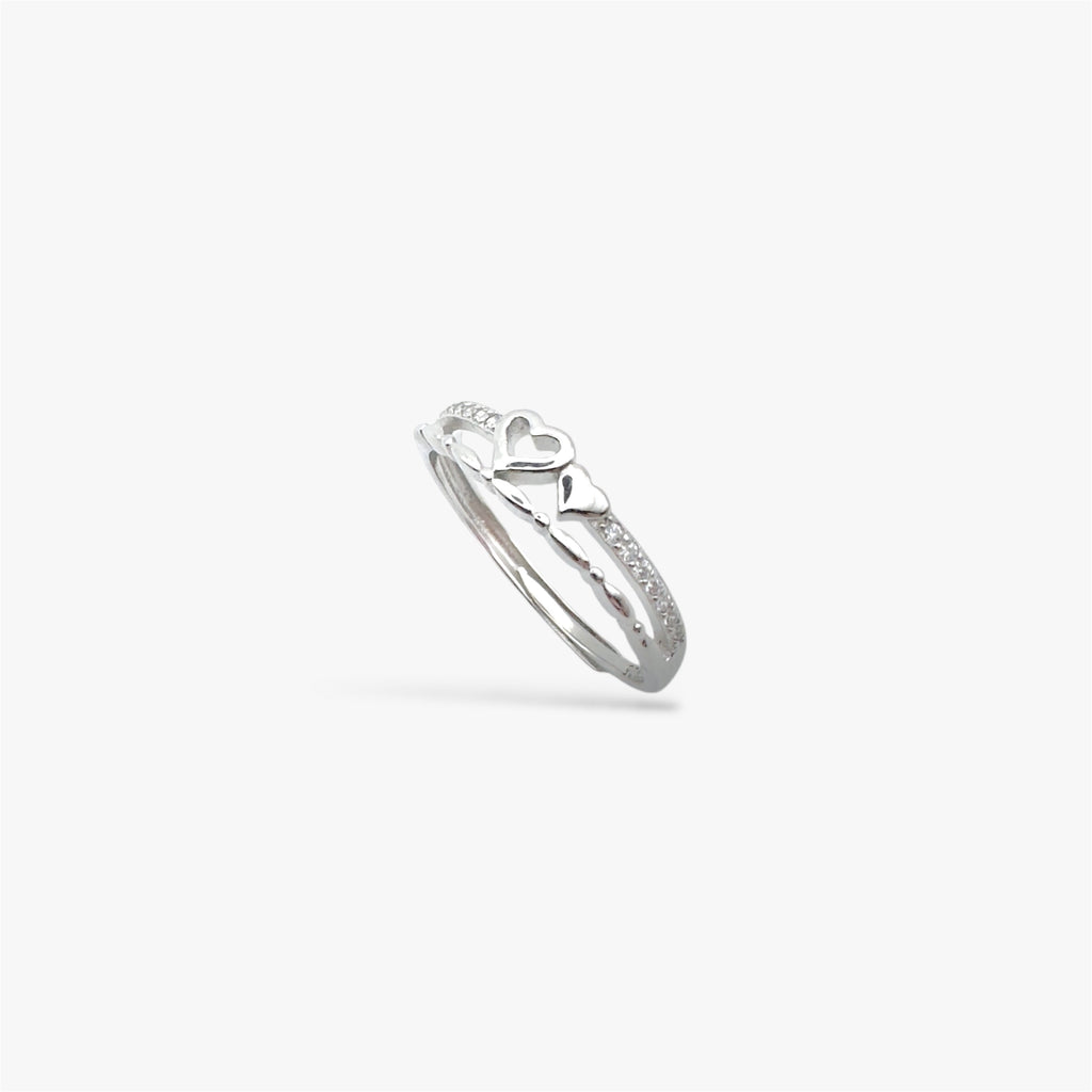 Silver ring with a heart design and crystals at a sideways angle view.